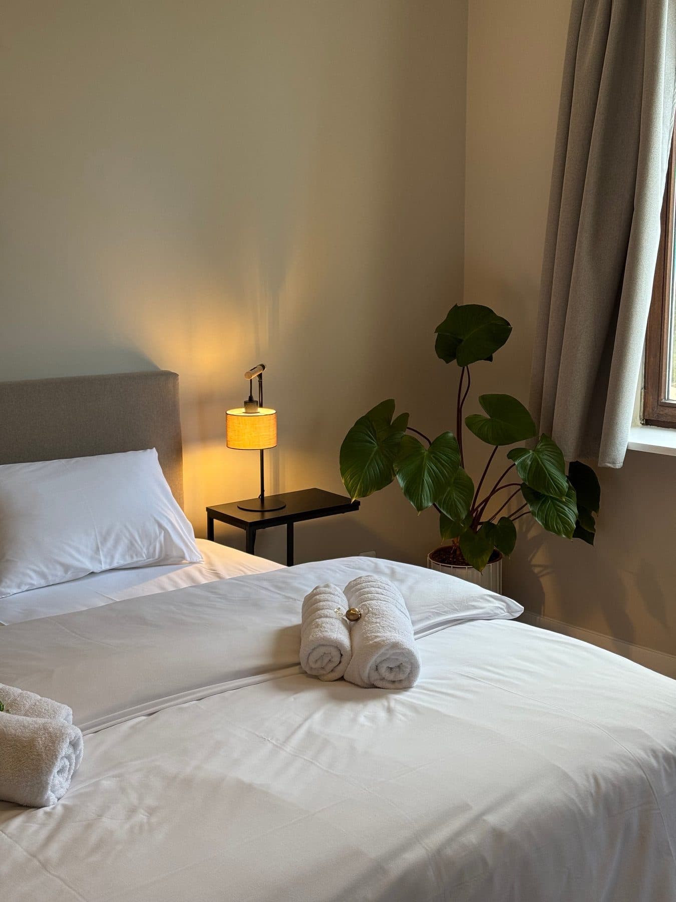 Hotelzimmer im Herzstykke mit Leselampe und Handtüchern auf dem Bett